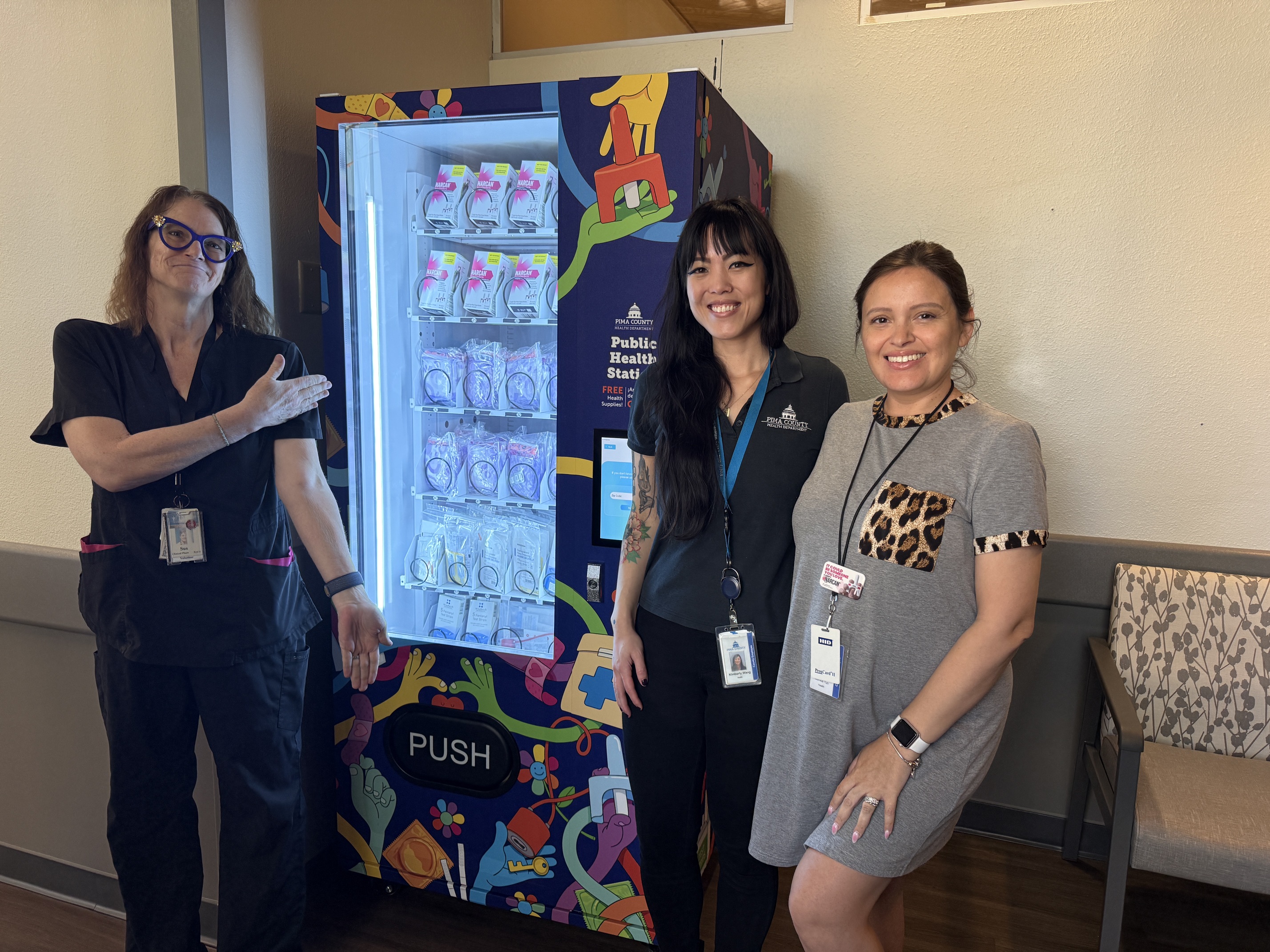 Three women stand n front of new public health vending machine at the TMC Emergency Department